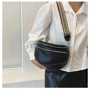 Detail of black lychee grain leather crossbody bag with striped wide fabric strap