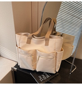 Detail view of large capacity canvas tote bag featuring double front zipper pockets