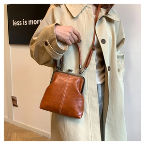 Brown retro leather doctor bag with metal clasp shown in a minimalist lifestyle setting