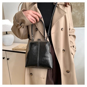 Detail of vintage black frame handbag with white contrast stitching and round handle