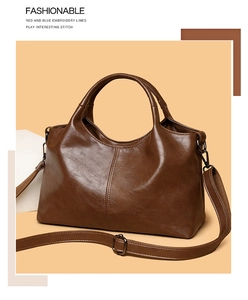 Detail of vintage brown leather handbag with adjustable strap and dark metal hardware