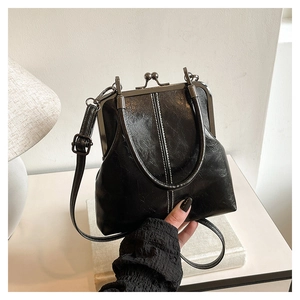 Detail of vintage black patent leather shell bag with silver metal frame and double bead clasp