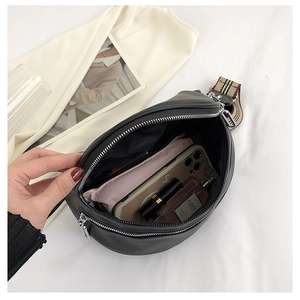 Close-up of black leather crossbody bag showing large interior space and checkered strap