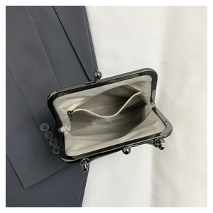 Detail view of vintage kiss-lock bag with herringbone lining and interior zipper pocket