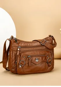 Detail view of brown PU leather shoulder bag featuring multiple functional zipper pockets