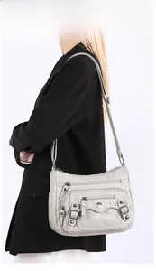 Close-up of light grey multi-pocket PU leather shoulder bag with adjustable strap details