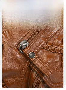 Close-up of textured brown leather bag with high-quality metal zipper and puller details