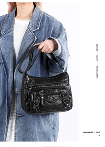 Detailed close-up of premium black cowhide leather texture on a multi-pocket shoulder bag