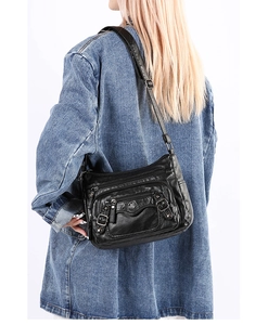 Detail of multi-pocket black PU leather crossbody bag with metallic logo and adjustable strap