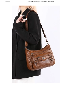 Detail of vintage brown PU leather shoulder bag with multi-pocket design and adjustable strap