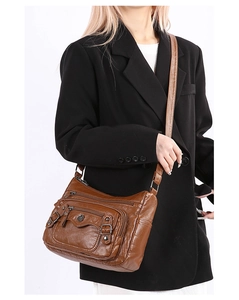 Detail of brown soft PU leather crossbody bag with multiple zipper pockets and metal buckle