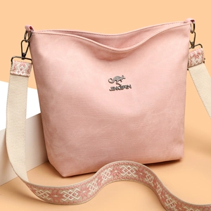 Détail du sac à bandoulière en toile rose avec logo kangourou et sangle de style ethnique