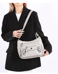 Detail of soft PU leather shoulder bag with multi-zipper layers and side pockets