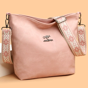 Détail du sac en toile rose avec bandoulière brodée ethnique et logo en métal poli