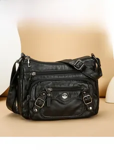 Detail view of the black soft PU leather shoulder bag with multiple zipper pockets