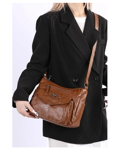 Detail of vintage brown faux leather crossbody bag with multi-pocket and woven stitching