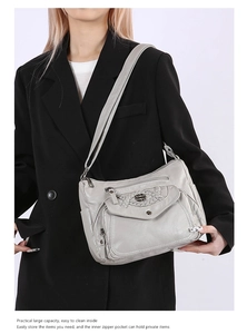 Detail showing high-capacity grey soft leather crossbody bag worn on model shoulder