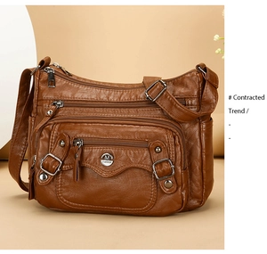 Detail of a brown PU leather shoulder bag with multiple zippered pockets and metal logo