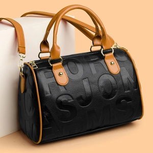 Detail of black leather Boston bag featuring letter embossing and brown handles