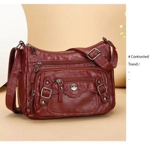 Detail of wine red PU leather shoulder bag with zipper pockets and lychee grain texture