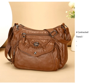 Detail of soft brown PU leather shoulder bag with multiple zippers and woven flap pocket
