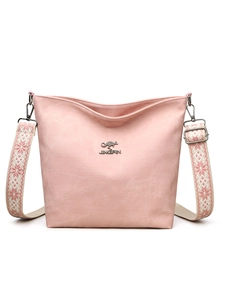 Détail du sac en toile rose avec bandoulière ethnique et logo métallique gravé