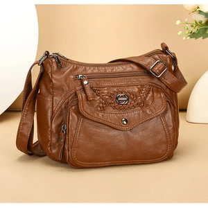 Detail of soft brown PU leather crossbody bag featuring multiple zipper pockets and stitching