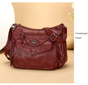 Detail of burgundy faux leather crossbody bag with braided flap and metal buckle
