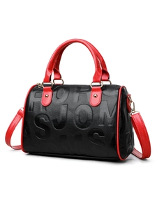 Detail of Boston bag showing lychee grain leather with red handle and gold ring buckle