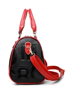 Macro detail of the contrast red piping and embossed leather texture on this black handbag
