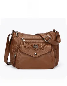 Detail of brown faux leather crossbody bag showing intricate weave and silver buckle