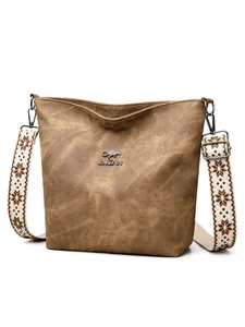 Détail du sac seau marron vintage avec bandoulière tissée aux motifs géométriques bohèmes