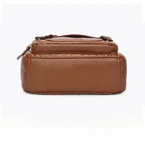 Close-up of the brown faux leather bag bottom with high-quality stitching and lychee texture