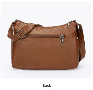 Detailed back view of brown soft leather crossbody bag with silver zipper pocket and strap