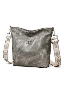 Gros plan du sac gris texturé avec logo kangourou et bandoulière tissée large
