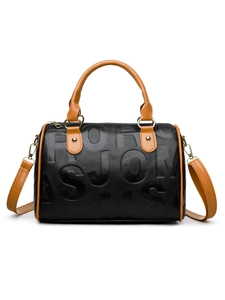 Close-up of embossed letter texture on black and brown leather boston handbag