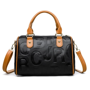 Detail of black lychee grain leather handbag with embossed letters and brown handles