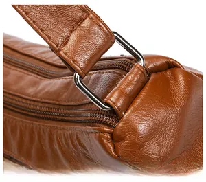 Detail of high-quality silver metal D-ring buckle and brown lychee textured leather strap