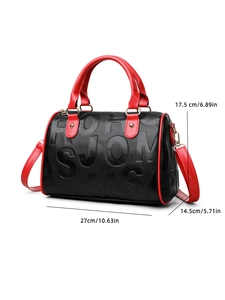 Detail view of black textured leather bag with red handles and dimensions 27x14.5x17.5cm