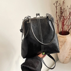 Classic black shell handbag with retro metal clasp and elegant white stitching detail