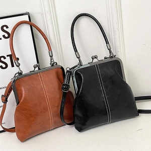 Vintage shell-shaped handbag in brown and black with metal frame closure and shoulder strap