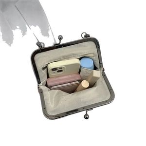 Minimalist shell-shaped crossbody bag with interior zip pocket and lining details