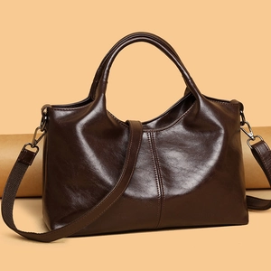 Minimalist large dark brown glossy leather tote bag with shoulder strap on retro background