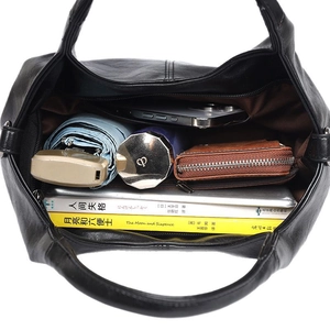 Large black leather tote bag showing spacious interior with books and daily essentials
