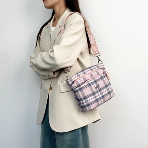 Pink plaid shoulder bag detail showing pink white check fabric and multi-zipper layers