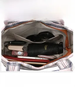 Detail showing the large capacity and inner pockets of the plaid canvas tote bag