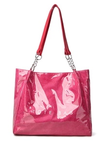 Détail macro du cabas magenta brillant avec texture gaufrée et logo TOTE BAG blanc