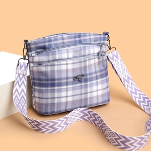 Blue and purple plaid canvas crossbody bag with metal kangaroo logo and wide geometric strap