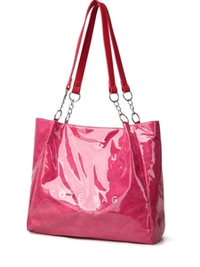 Détail du sac cabas fuchsia brillant avec bandoulière rouge et chaîne argentée
