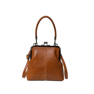 Vintage brown leather doctor bag with kiss-lock clasp and shoulder strap on white background